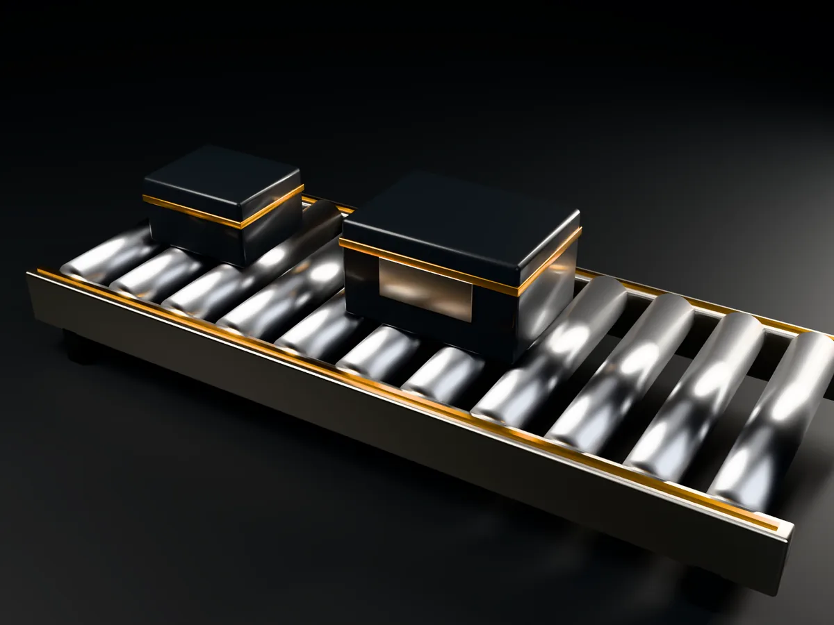 Steel conveyor rollers carrying two dark parcels banded in amber, an amber line along the frame